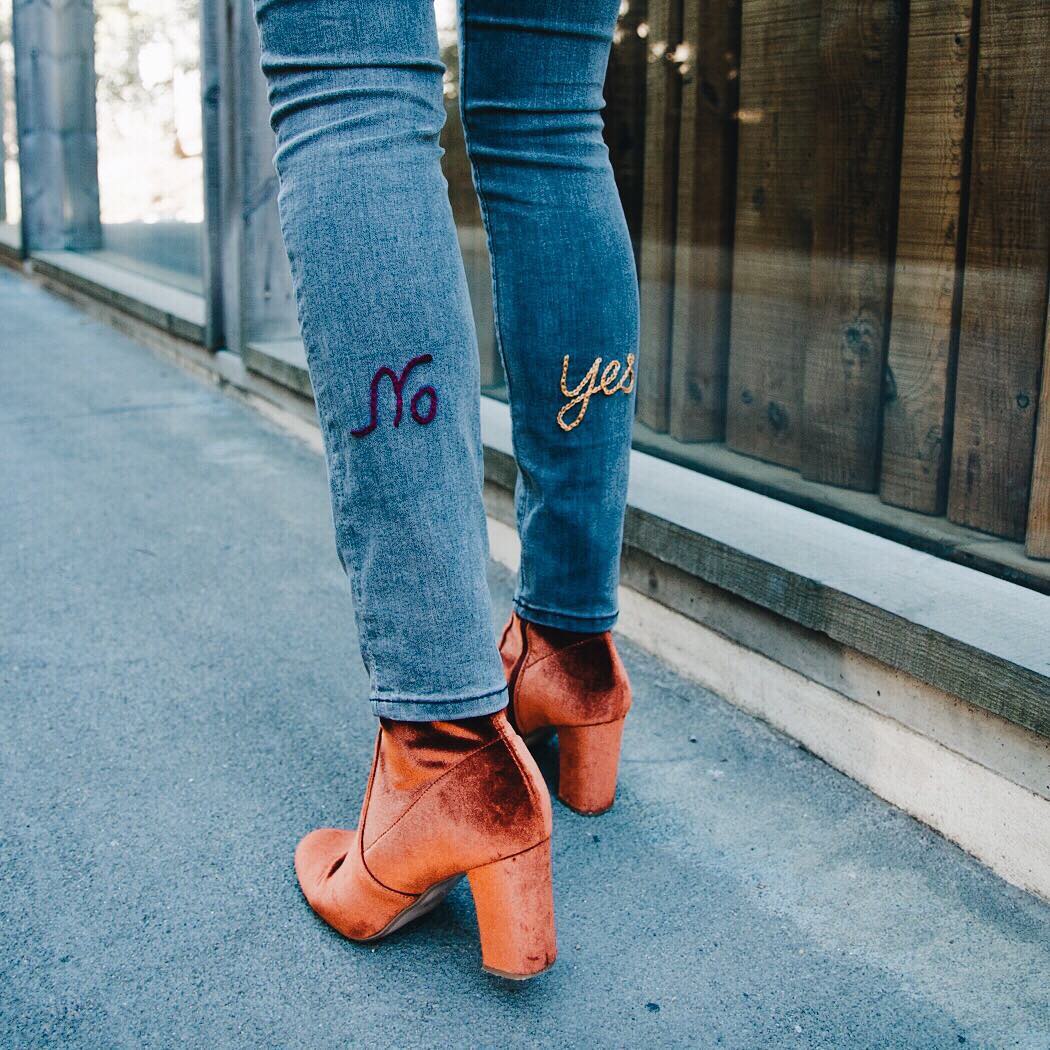 Jeans mit gesticktem „No“ und „yes“ auf den Hosenbeinen